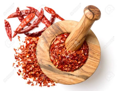 dried red chilli flakes in the wooden mortar, isolated on white background